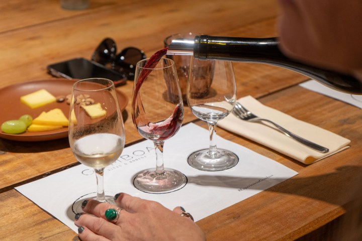 a glass of wine sitting on top of a wooden table